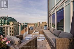 Ottawa condo for rent - A patio with a table and chairs overlooking a cityscape.