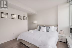Ottawa condo for rent - A bedroom with a large bed and pictures on the wall.