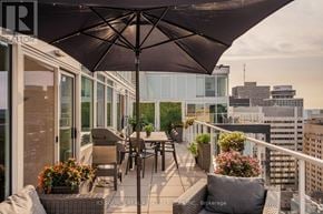 Ottawa condo for rent - A balcony with a table and chairs under an umbrella.
