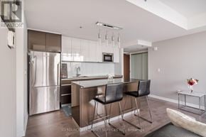 Ottawa condo for rent - A modern kitchen with a refrigerator, sink, and bar stools.