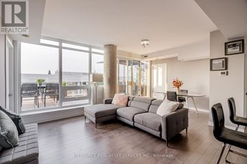 Ottawa condo for rent - A living room with a grey couch and a large window.