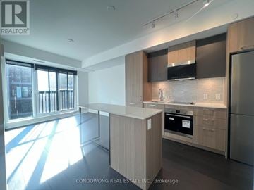Toronto (Regent Park) condo for rent - A modern kitchen with wooden cabinets and stainless steel appliances.