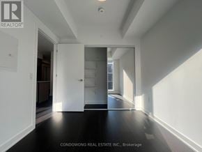 Toronto (Regent Park) condo for rent - A spacious room with white walls and a black floor.