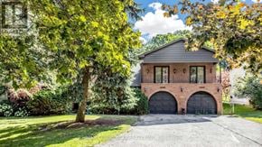 Toronto (Scarborough Village) apartment for rent - A house with a brick facade and a grey roof is surrounded by greenery.