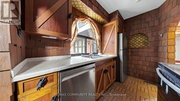 Toronto (Scarborough Village) apartment for rent - A kitchen with wooden cabinets and a brick wall.