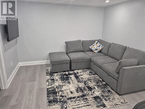 Brantford apartment for rent - A grey sectional sofa with a patterned rug in front of it.