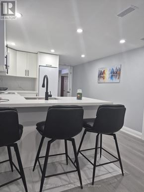 Brantford apartment for rent - A modern kitchen with a white countertop and black barstools.