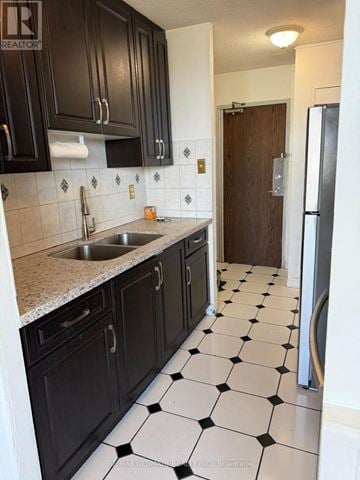 Toronto (Dorset Park) condo for rent - A kitchen with black cabinets and a checkered floor.