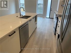 Tillsonburg condo for rent - A kitchen with a sink, refrigerator, and cabinets.