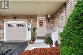 Innisfil (Alcona) townhouse for rent - A house with a white garage door and a red brick wall.