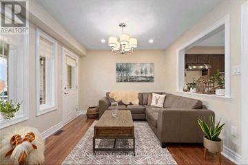 Innisfil (Alcona) townhouse for rent - A living room with a grey couch and a chandelier.