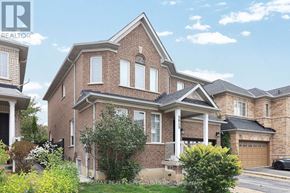 Mississauga (Churchill Meadows) apartment for rent - A large brick house with a garage and a car parked in front.