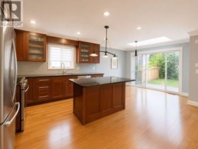 Vancouver apartment for rent - A kitchen with wooden cabinets and a black countertop.