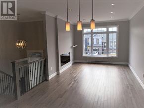St. John's apartment for rent - A well-lit room with wooden floors and a large window.
