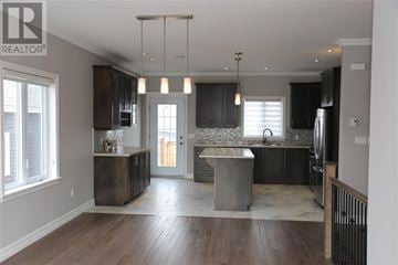St. John's apartment for rent - A modern kitchen with dark wood cabinets and a central island.