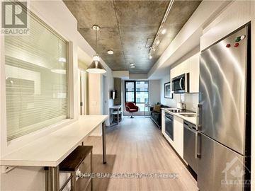 Ottawa condo for rent - A modern kitchen with stainless steel appliances and a dining area.