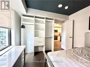 Ottawa condo for rent - A bedroom with a bed, desk, and drawers.