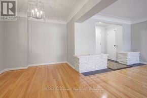 Burlington (Brant) multi-family for rent - A room with wooden flooring and white walls, with a light fixture hanging from the ceiling.