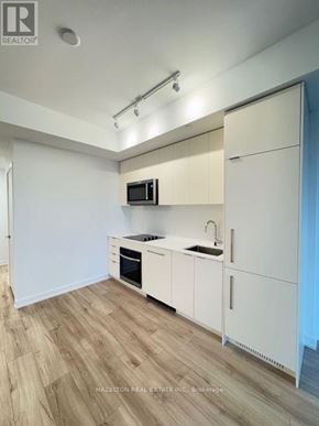 Toronto (Willowdale East) condo for rent - A kitchen with white cabinets and a wooden floor.