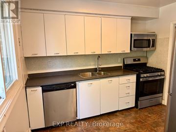 Toronto (Woburn) apartment for rent - A kitchen with white cabinets and a black counter top.