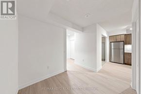 Toronto (Humber Heights) condo for rent - A white room with a wooden floor and a door leading to a kitchen.