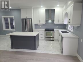 Hamilton (Mcquesten) apartment for rent - A modern kitchen with white cabinets and a marble countertop.