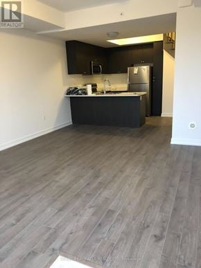 Pickering (Town Centre) townhouse for rent - A kitchen with a black countertop and a refrigerator.