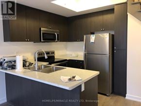 Pickering (Town Centre) townhouse for rent - A kitchen with a refrigerator, microwave, and oven.