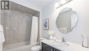 Centre Wellington (Fergus) townhouse for rent - A bathroom with a tub, sink, and mirror.