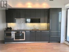 Toronto (Bayview Village) condo for rent - A modern kitchen with dark grey cabinets and stainless steel appliances.
