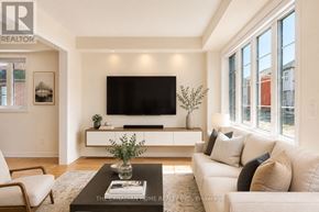 Woolwich apartment for rent - A living room with a white couch and a flat screen TV mounted on the wall.