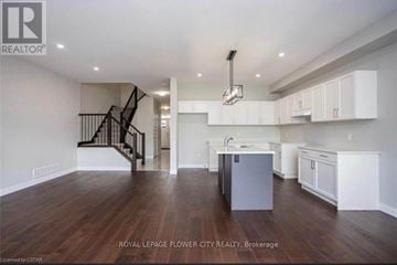 London South (South W) townhouse for rent - A spacious kitchen with white cabinets and a dark wood floor.