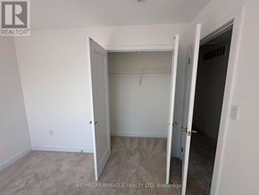 Guelph (Clairfields/Hanlon Business Park) townhouse for rent - A room with a carpeted floor and a doorway leading to another room.