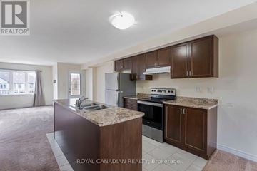 Cambridge townhouse for rent - A kitchen with brown cabinets and a granite countertop.