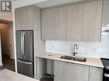 Kitchener condo for rent - A kitchen with a sink and a refrigerator.