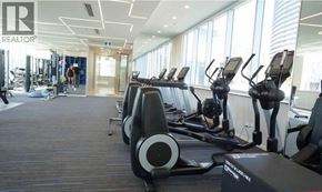 Burnaby apartment for rent - A gym with treadmills and a REALTOR sign.