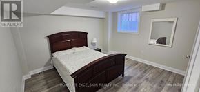 Markham (Wismer) apartment for rent - A bedroom with a bed, nightstand, and mirror.
