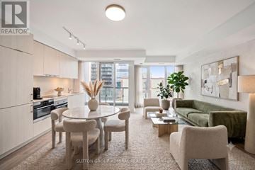 Toronto (Moss Park) condo for rent - A well-lit, modern kitchen and living room with a dining table and chairs.