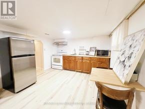 Toronto (Oakwood Village) apartment for rent - A kitchen with wooden cabinets and a stainless steel refrigerator.