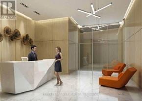 Toronto (Niagara) condo for rent - A woman in a black dress stands at a reception desk in a well-lit office.