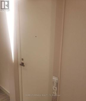 Toronto (Niagara) condo for rent - A white door with a silver handle and a small black dot on the wall.