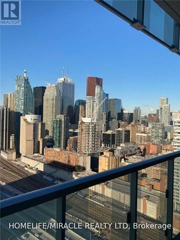 Toronto (Waterfront Communities) condo for rent - A cityscape with a clear blue sky and buildings of various heights and designs.