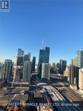 Toronto (Waterfront Communities) condo for rent - A cityscape with a clear blue sky and a building under construction in the foreground.