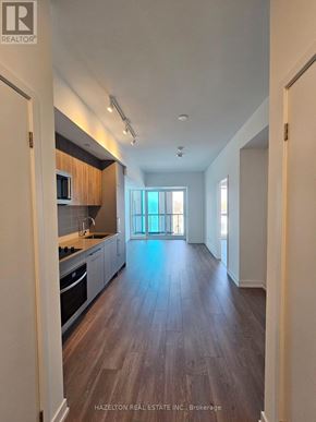 Toronto (Willowdale East) condo for rent - A spacious kitchen with wood flooring and a view of the outdoors through a large window.