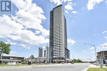 Vaughan (Concord) condo for rent - A tall building with a curved facade stands in the foreground of a city street.