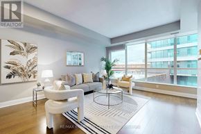Mississauga (Port Credit) condo for rent - A living room with a white couch, a coffee table, and a large window.
