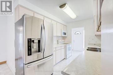 Mississauga (Malton) apartment for rent - A modern kitchen with a stainless steel refrigerator and white cabinets.