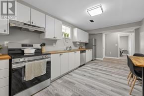 Southgate apartment for rent - A modern kitchen with a stove top oven and a dining table.