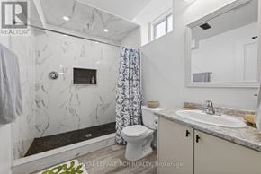 Southgate apartment for rent - A bathroom with a marble wall and a toilet.