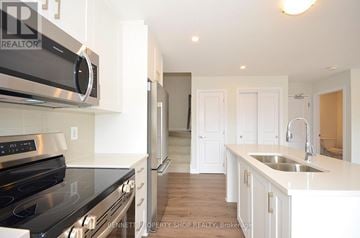 Ottawa townhouse for rent - A modern kitchen with white cabinets and stainless steel appliances.